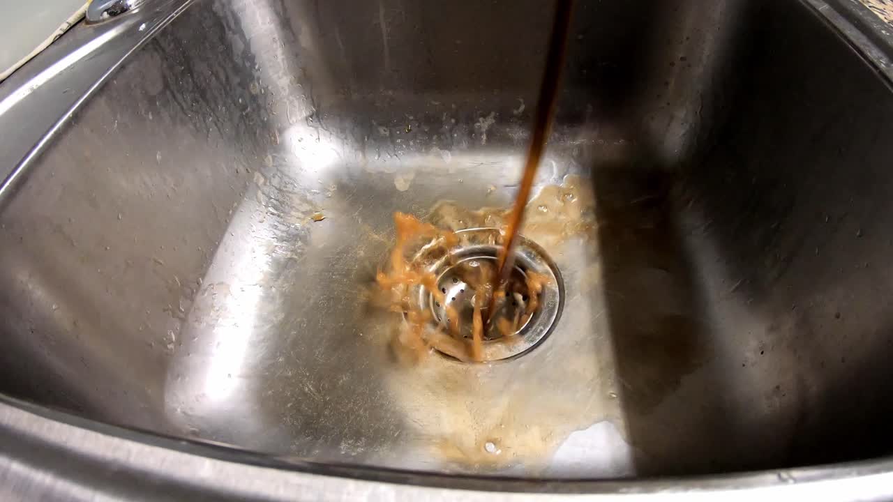 comenzando afuera, luego lentamente en un fregadero, vertiendo dos litros de refresco en un fregadero