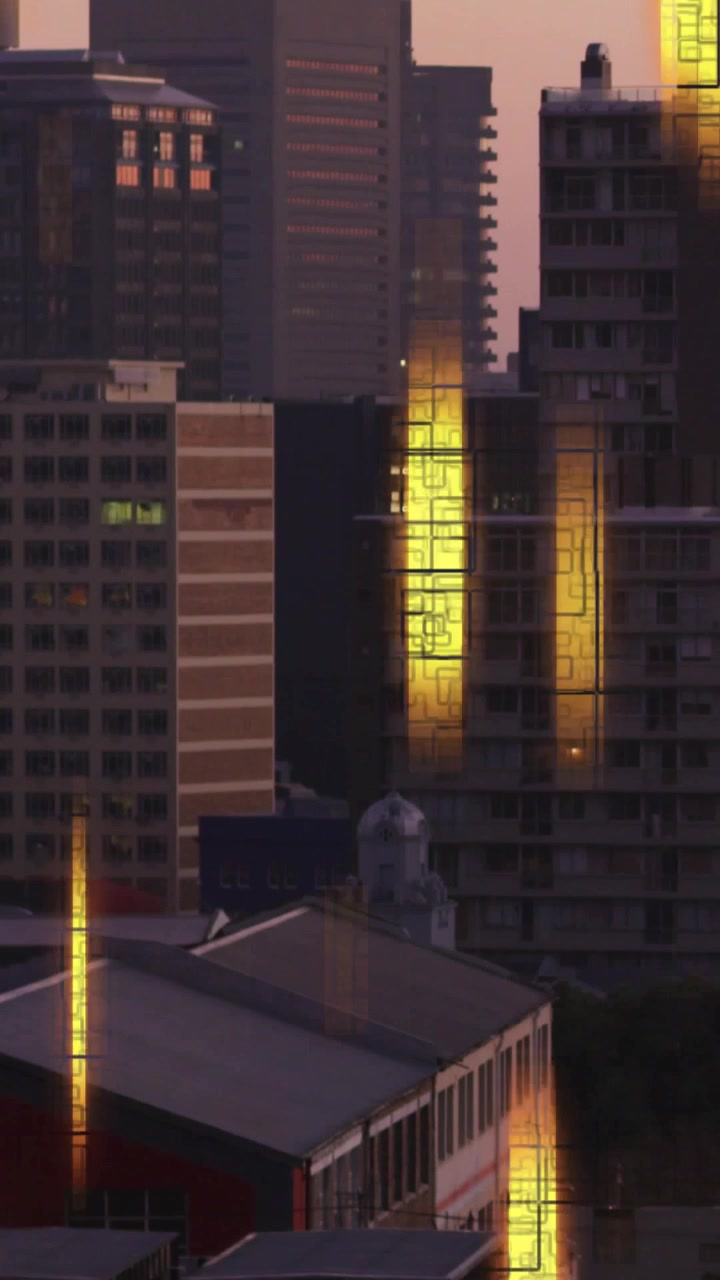 Video vertical: Luz solar rozando torres, formando bandas verticales doradas que viajan y se desvanecen al atardecer.
