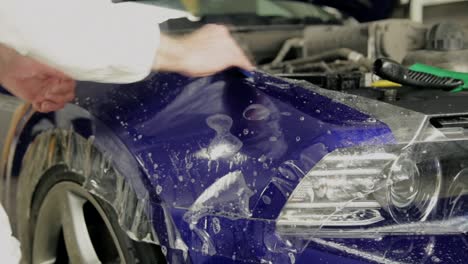 applying paint protection film to a blue car