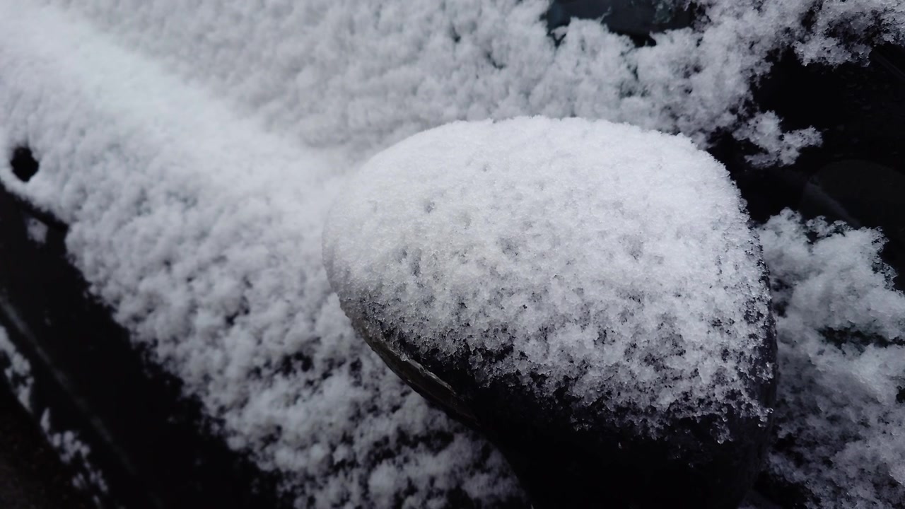 Lenta panoramica in avanti verso lo specchietto laterale di un'auto coperto di neve. Questo filmato è ideale per temi invernali, stagione fredda, ambiente, veicoli in inverno e temi commerciali