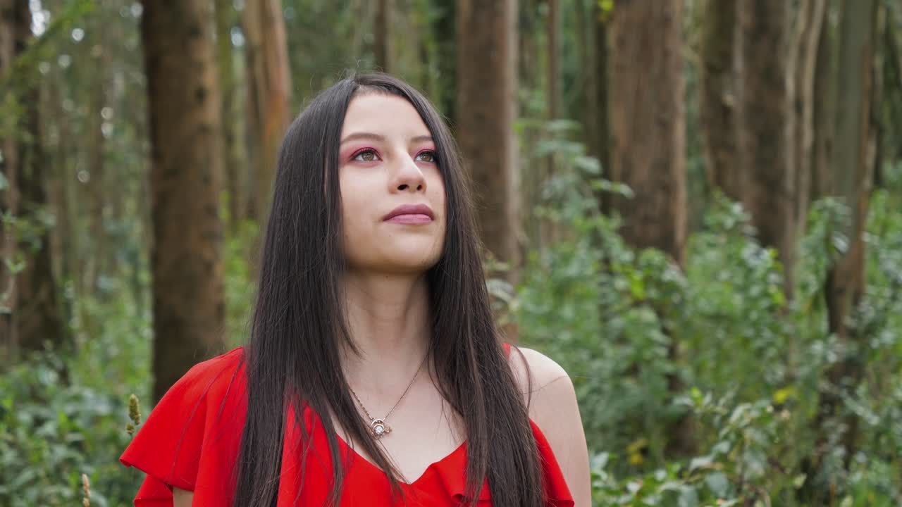 bastante joven latina, mujer morena de pie en un bosque y disfrutando de la naturaleza