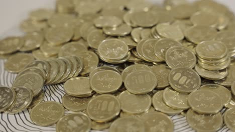 collection of 500 yen coins, golden japanese currency on table