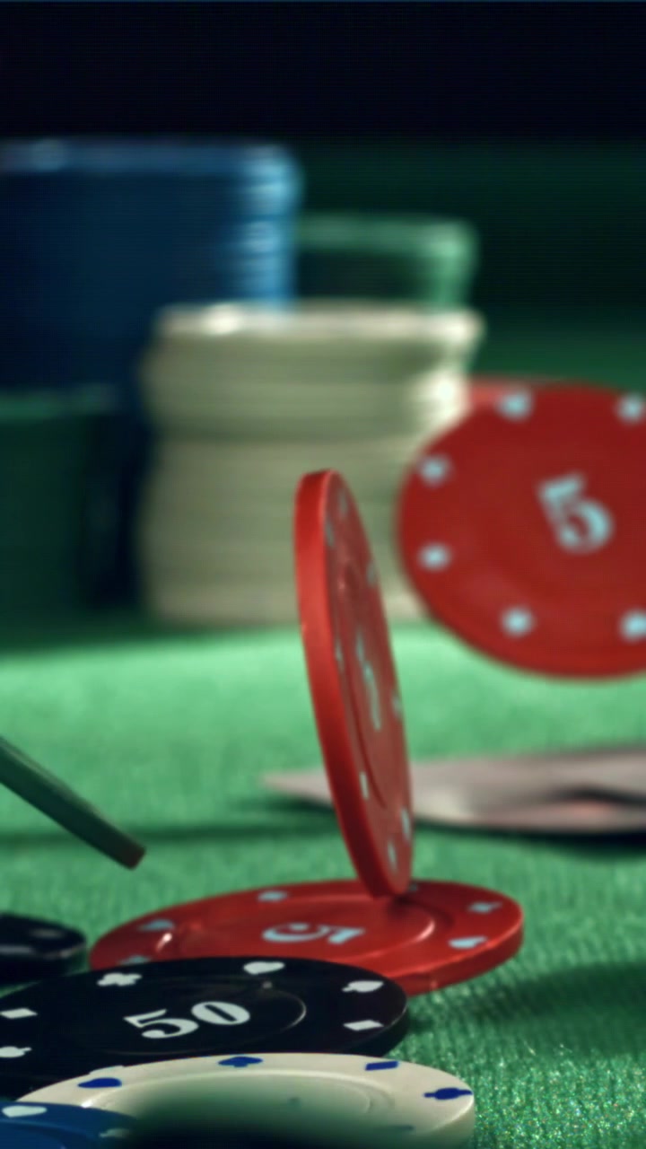 Zwolnione tempo: kolorowe żetony pokerowe spadające na zielony stół