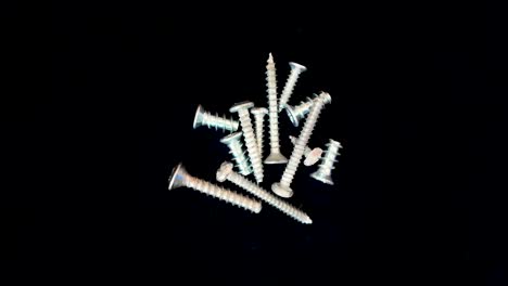 metal screws rotating in synchronization against a black backdrop, industrial design, clean black background