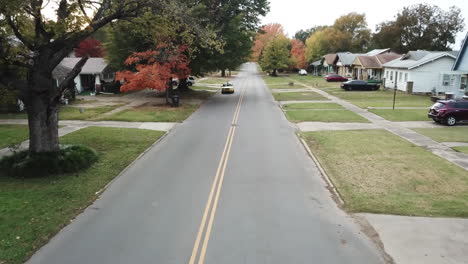 Aerial-dolly-past-a-taxi-driving-through-a-neighborhood-in-Georgia