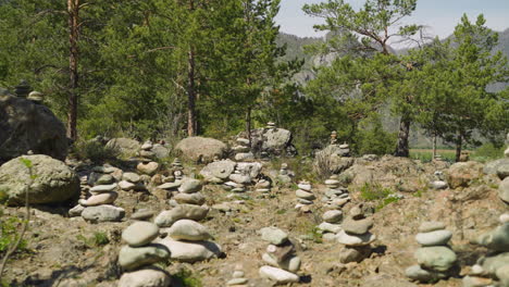 pebble pyramids near pine wood at altai on sunny day