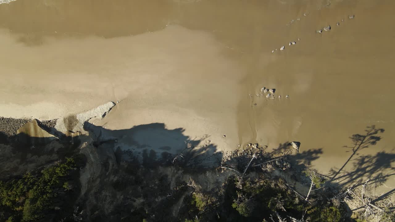 tomada de un dron de arriba hacia abajo de las olas rodando en una playa en newport, oregon