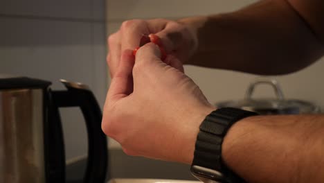 un modelo de mano masculino blanco pela la piel de los tomates en cámara lenta