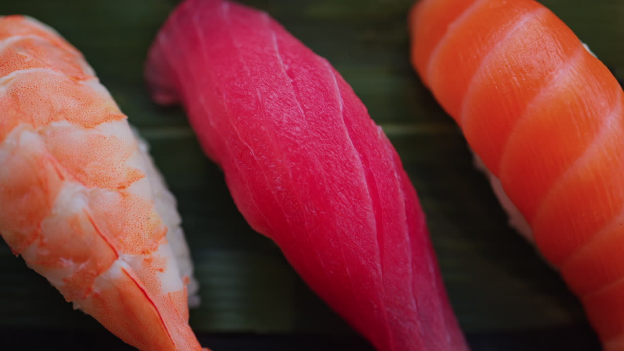 Close up of multiple nigiri on a black tray at a restaurant