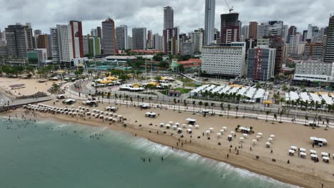 people at the mansa beach with beachside market and hotels in fortaleza, brazil. - aerial shot