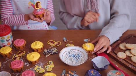 mother and child decorating cupcakes. static shot.