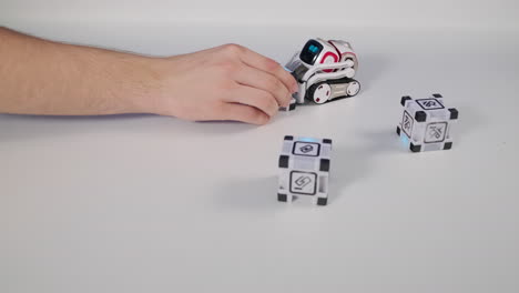 person playing with a toy robot and cubes