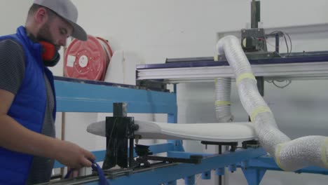 un hombre que hace tablas de surf en su taller