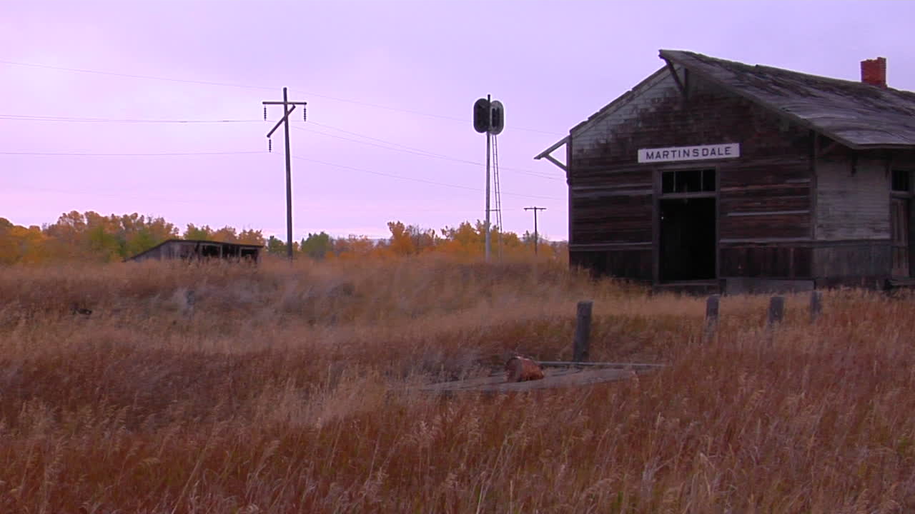 una antigua estación se encuentra en un campo cerca de una vía férrea 1