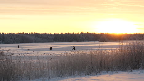 Pescador-De-Hielo-En-Un-Hermoso-Lago-Cubierto-De-Nieve-Congelada-Al-Amanecer