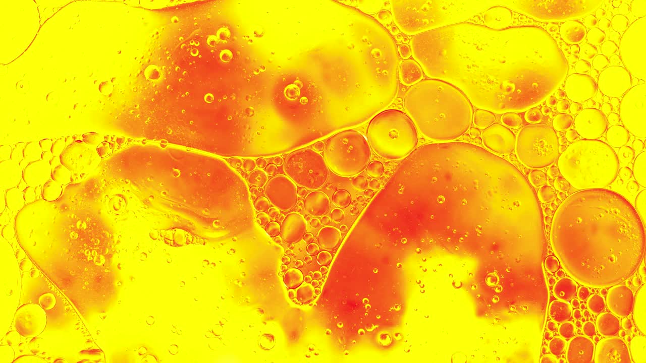 Colorful oil drops floating on water surface, top view. Fantastic abstract background. Bright bubbles moving and spreading. Close up 4k video of weird liquid structures. Scientific chemical experiment