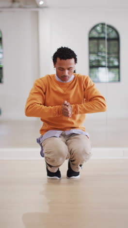 vertical video of happy biracial man dancing in dance studio