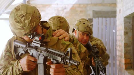 Front-view-of-caucasian-military-soldier-standing-and-aiming-with-rifle-during-military-training-4k