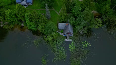 Aerial-reveal-shot-of-a-countryside-landscape-with-a-pond-in-the-forest