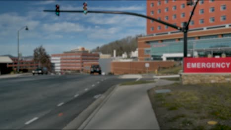 cars drive by an emergency room hospital establishing shot blurred blank plate