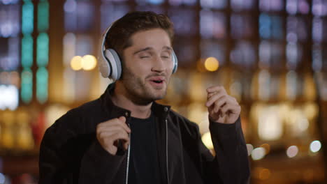 excited man enjoying music headphones on street. euphoric guy dancing outdoors.