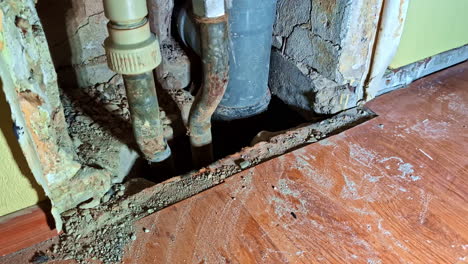 exposed pipes and damaged wall section inside building during renovation