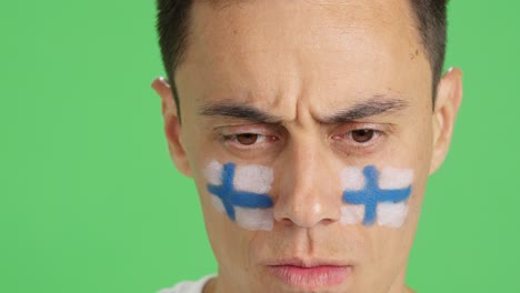 serious man with a finnish flag painted on the face