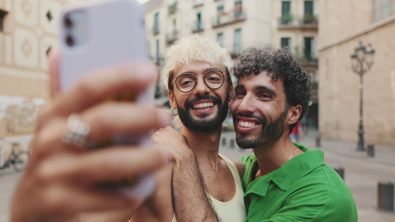 Coppia gay felice che si scatta un selfie in una strada di città