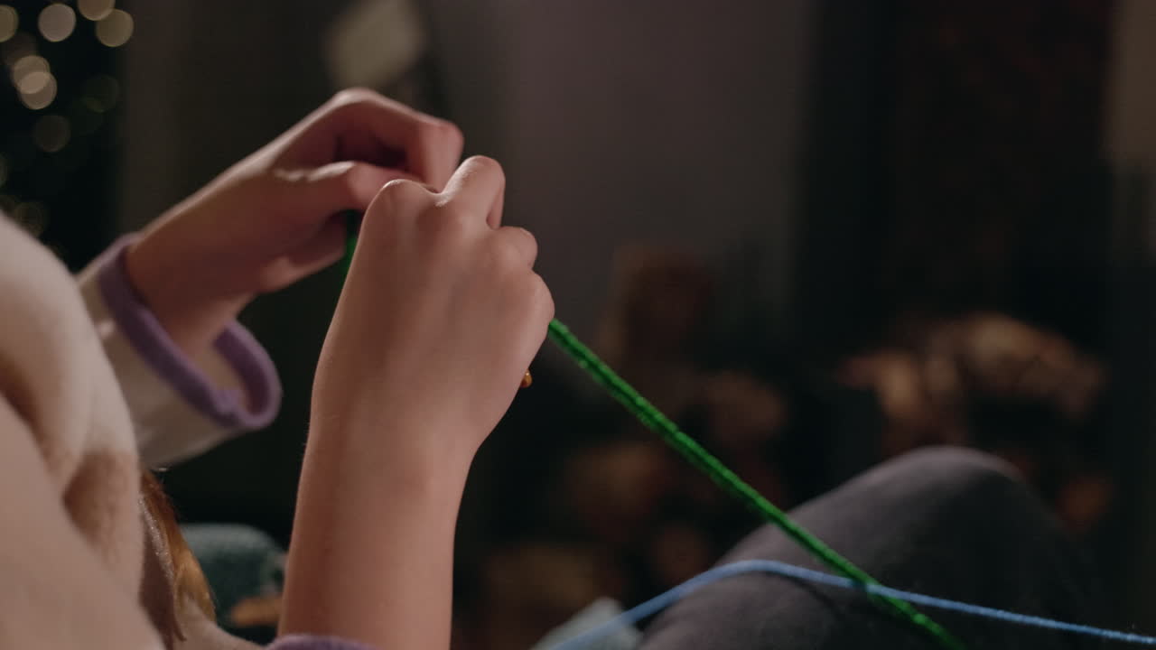 뜨개질하는 아이의 손의 클로즈업