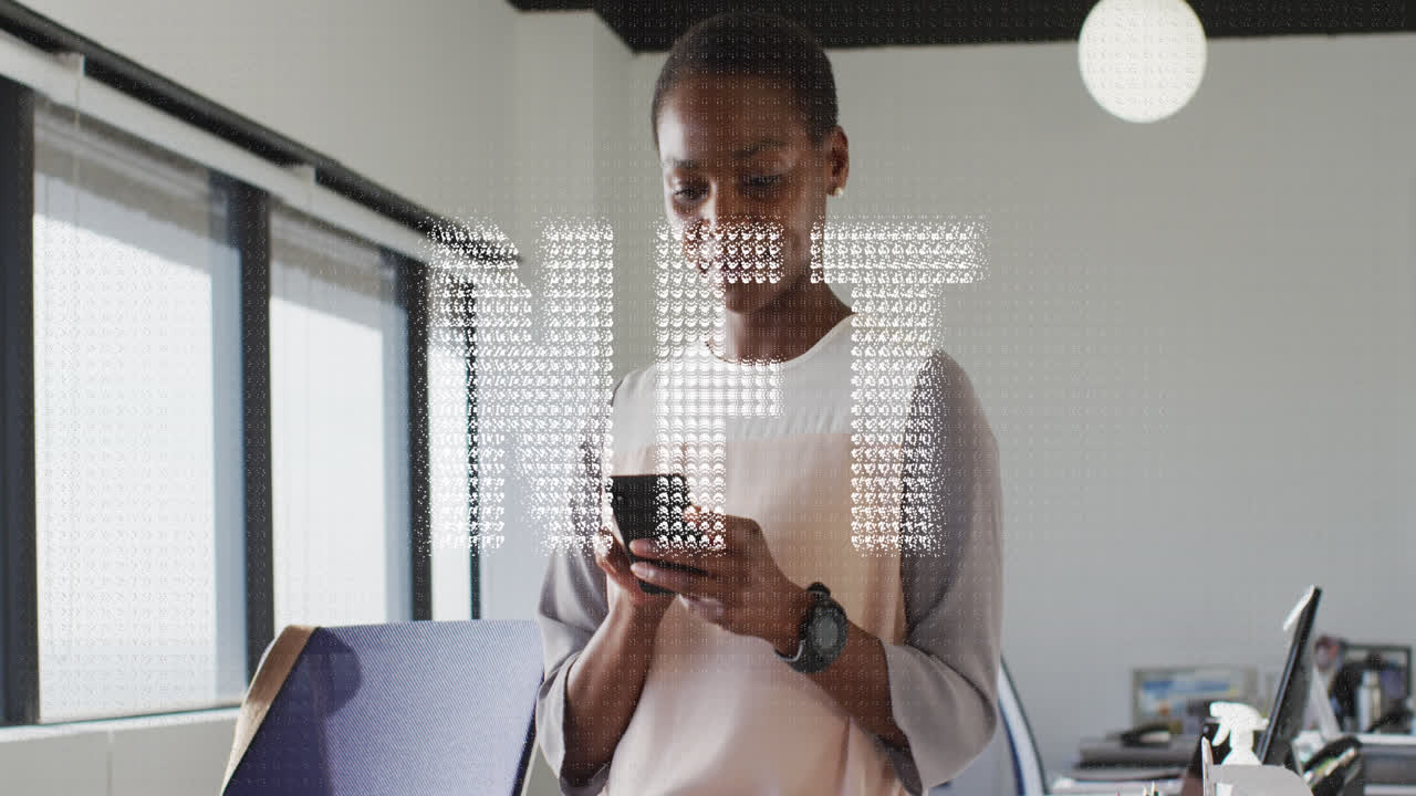 Animation of nft text banner against african american woman using smartphone at office
