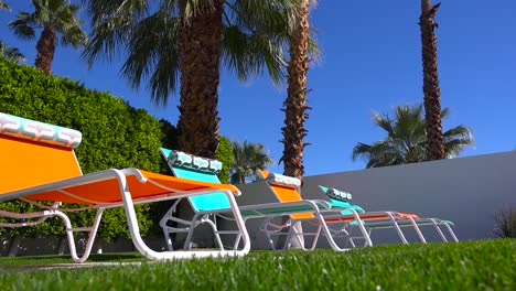 colorful lawn chairs sit around a pool at a palm springs home 1