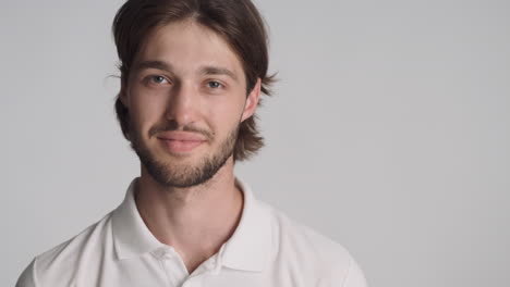 caucasian man in front of camera on gray background.