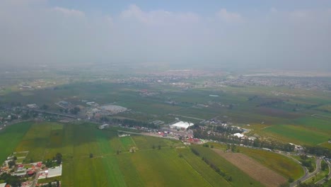 Vista-Aérea-De-Los-Campos-Agrícolas-Cerca-De-La-Ciudad-De-México-Y-Alrededor-De-Los-Volcanes