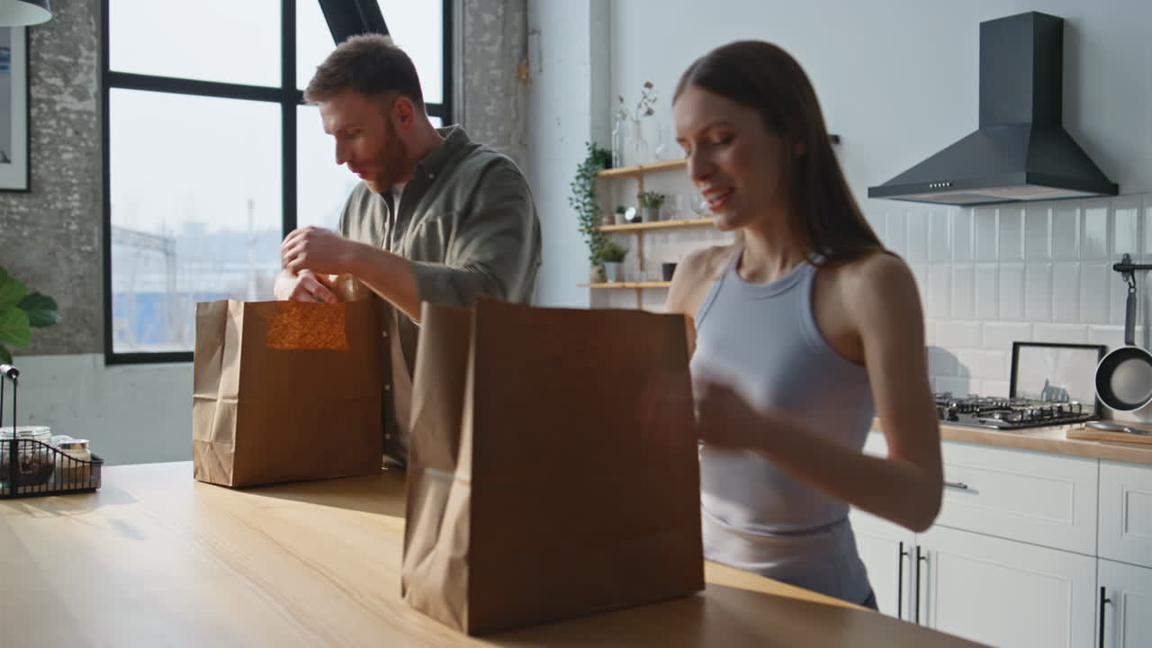 Smiling spouses bringing groceries to home kitchen closeup. Cheerful family