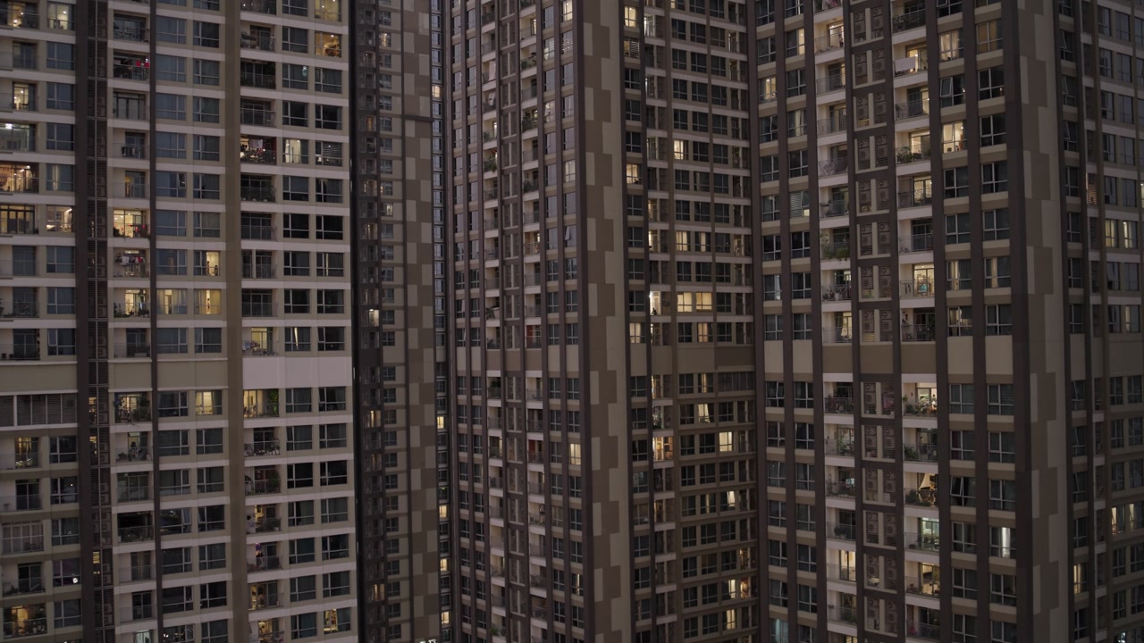 Towering Residential Skyscrapers With Illuminated Windows And Balconies At Dusk In Ho Chi Minh, Vietnam. elevated, static shot