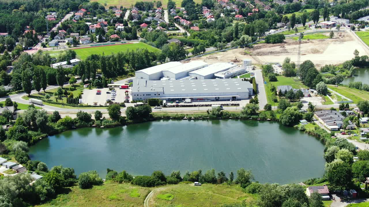 적재 허브가 있는 대형 물류 공원에서 상품을 하역하기 위해 창고 경사로에 화물 트레일러가 있는 세미 트럭의 공중 전망