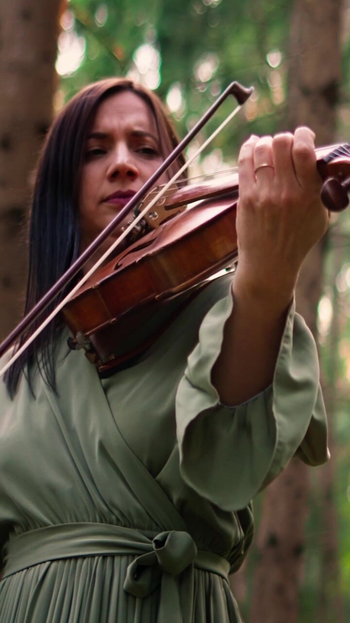 Woman Playing Violin in a Forest Setting