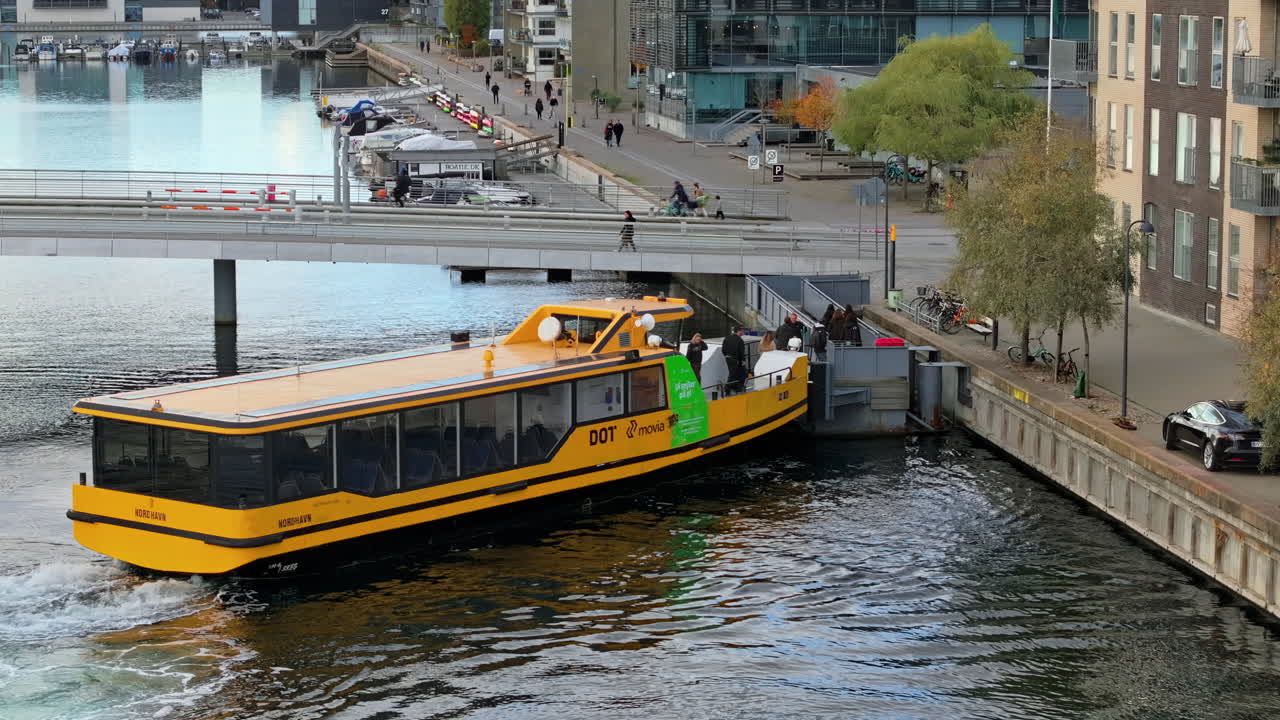 Aerial drone view of a yellow boat moving on the water in the Teglholmen peninsula in the South Harbour of Copenhagen, Denmark
