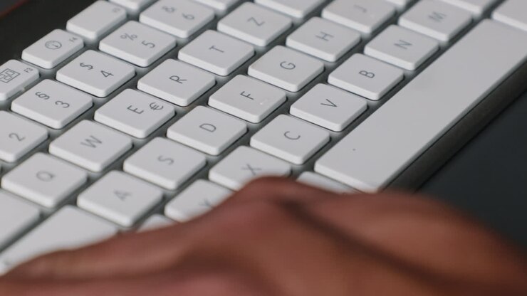 Extreme close up of male fingers and thumbs operating a stylish keyboard shortcut