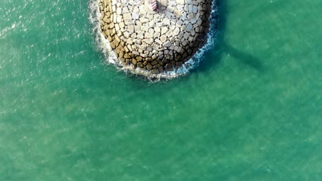 ocean and pontoon with a lighthouse in a sunny day