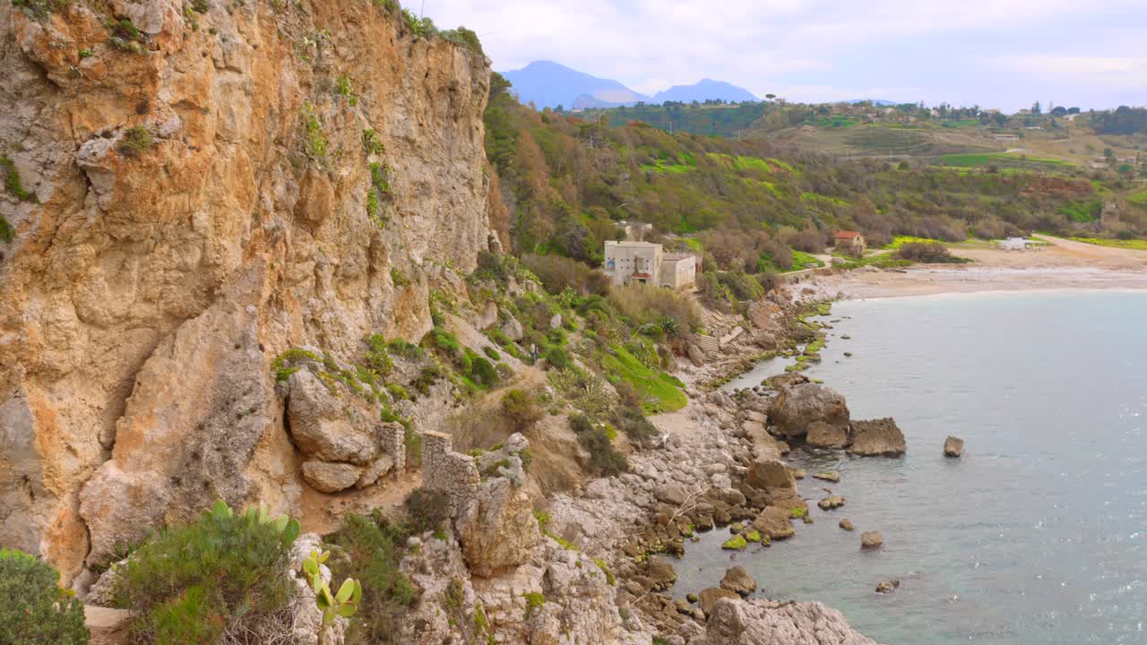 Pan view of a rocky coast during daytime in Sicily, Italy. 4k.