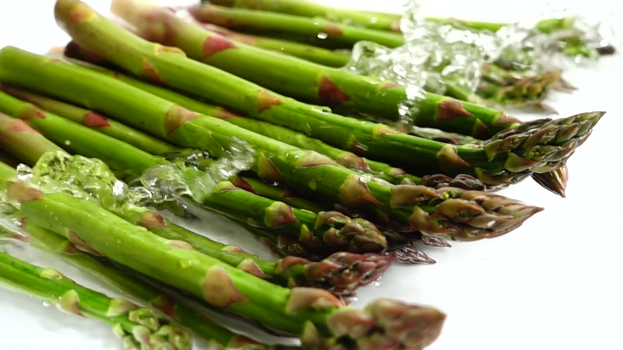 Asparagi verdi freschi. Schizzi d'acqua. Al rallentatore