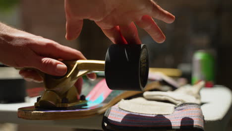 Man's-hands-come-into-frame-and-spin-longboard-wheel