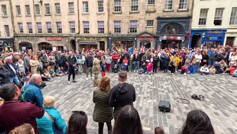 crowd gathers to watch street performers in edinburgh