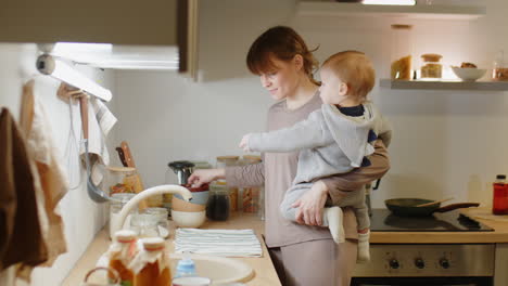 mother with baby standing in kitchen