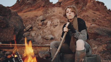 portrait of woman by campfire in post apocalyptic world