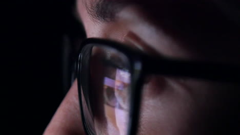 extreme close up of woman's eye as she scrolls through her social media feed late at night