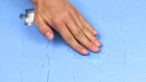 hand placing the last two pieces on a puzzle