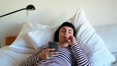 Woman-using-mobile-phone-in-bedroom-4k