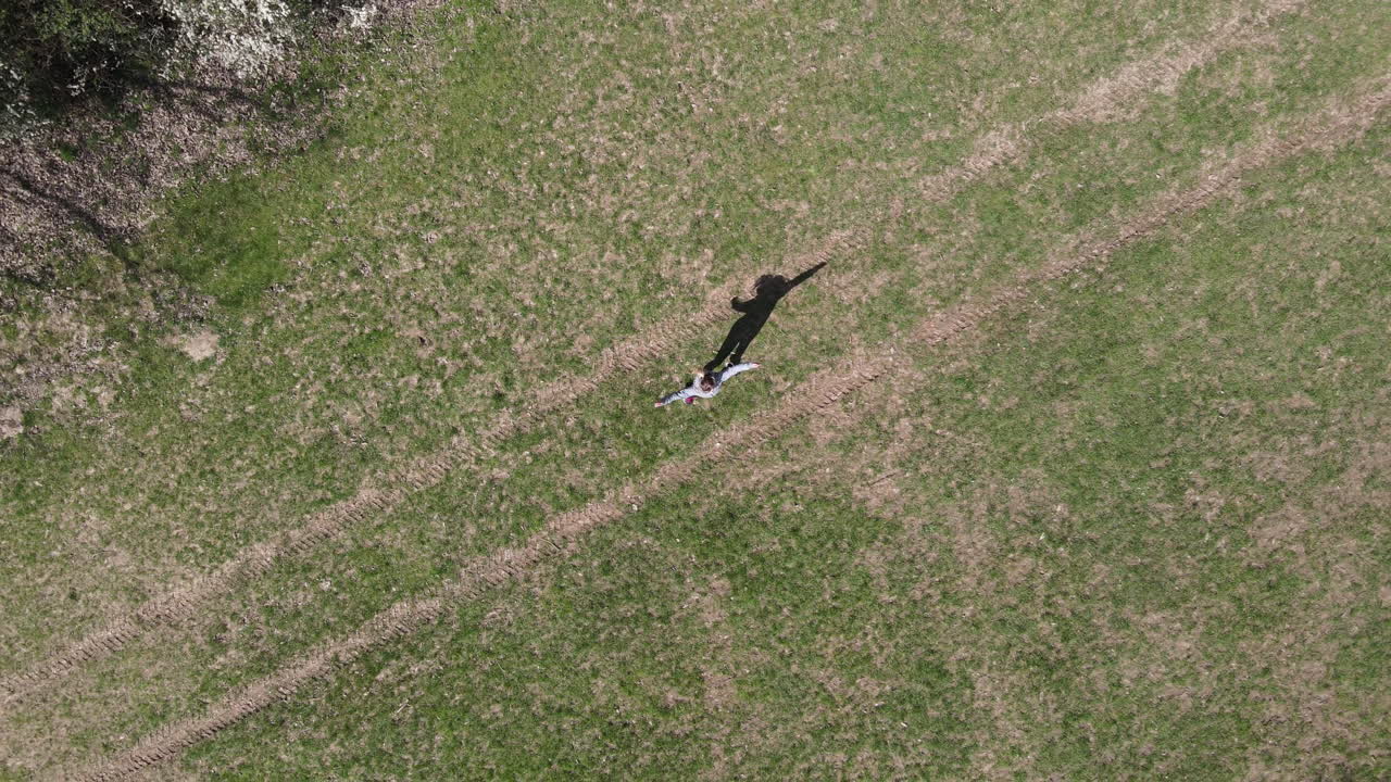 Fitness Model Doing Exercise in Park. Female Exercising in Woodlands. Outdoor Cardio Training. 4K Aerial Drone Shot From Above. Workout And Star Jumps.